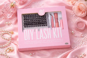 Kit Hunkylash DIY Lash Kit présenté dans son coffret rose, avec clusters de cils, bond, seal, remover et accessoires, mis en scÚne sur fond rose satiné avec perles et roses pour une esthétique beauté premium.