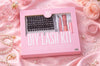 Kit Hunkylash DIY Lash Kit présenté dans son coffret rose, avec clusters de cils, bond, seal, remover et accessoires, mis en scène sur fond rose satiné avec perles et roses pour une esthétique beauté premium.